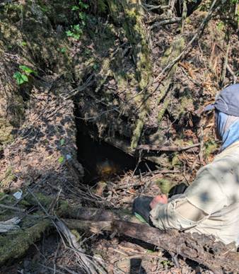 A person sitting in the ground near a hole in the ground AI-generated content may be incorrect.