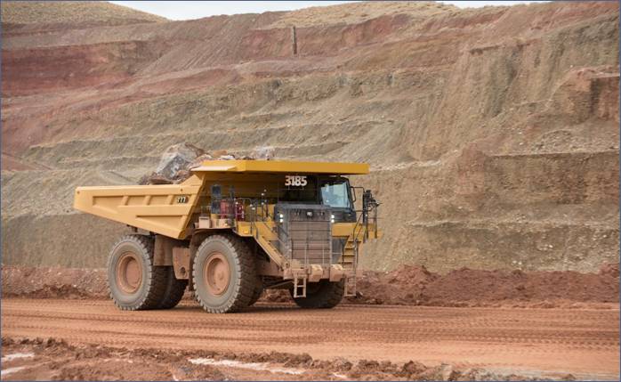 A large yellow truck in a quarry AI-generated content may be incorrect.