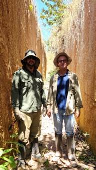Two men standing in a narrow tunnel AI-generated content may be incorrect.