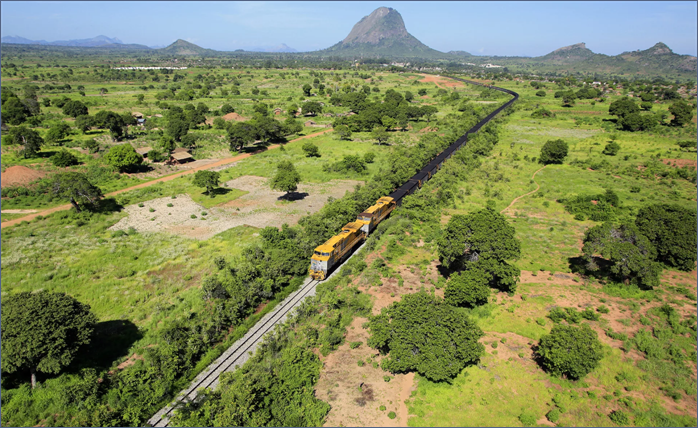 A train on the tracks in a green field AI-generated content may be incorrect.
