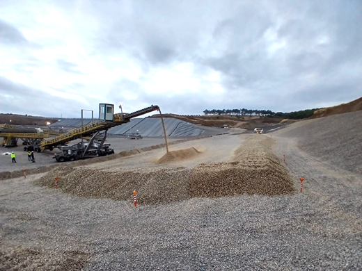 A machine pouring gravel into a pile of gravel AI-generated content may be incorrect.