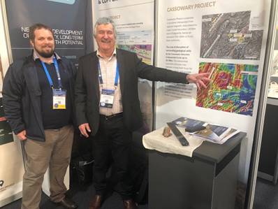 Two men standing next to a display AI-generated content may be incorrect.