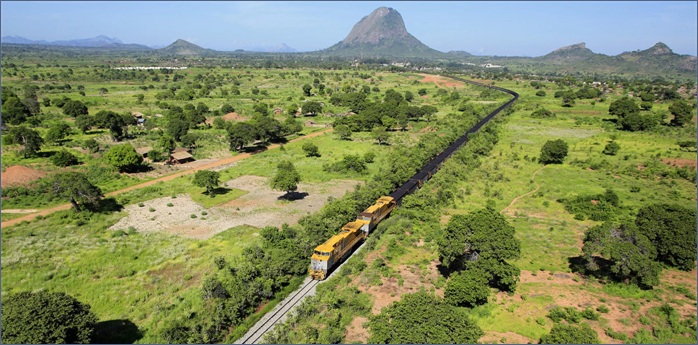 A train on the tracks in a green field AI-generated content may be incorrect.