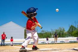 A child holding a baseball bat AI-generated content may be incorrect.