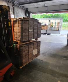 A forklift with a stack of wooden crates AI-generated content may be incorrect.