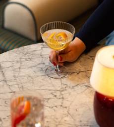 A hand holding a glass of liquid AI-generated content may be incorrect.