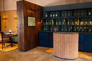 A bar with bottles of liquor on shelves AI-generated content may be incorrect.