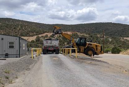 A construction vehicle loading a dump truck AI-generated content may be incorrect.