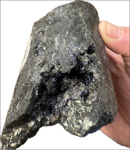 The hand is holding a handful of black, shiny crystals. AI-generated content may be incorrect.