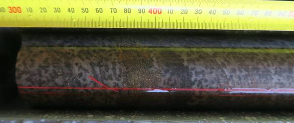 The image shows a large, rough metal sheet with a tape measure placed next to it, indicating measurements in centimeters. AI-generated content may be incorrect.
